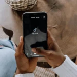 Main tenant un téléphone avec l'application TikTok d'ouverte.