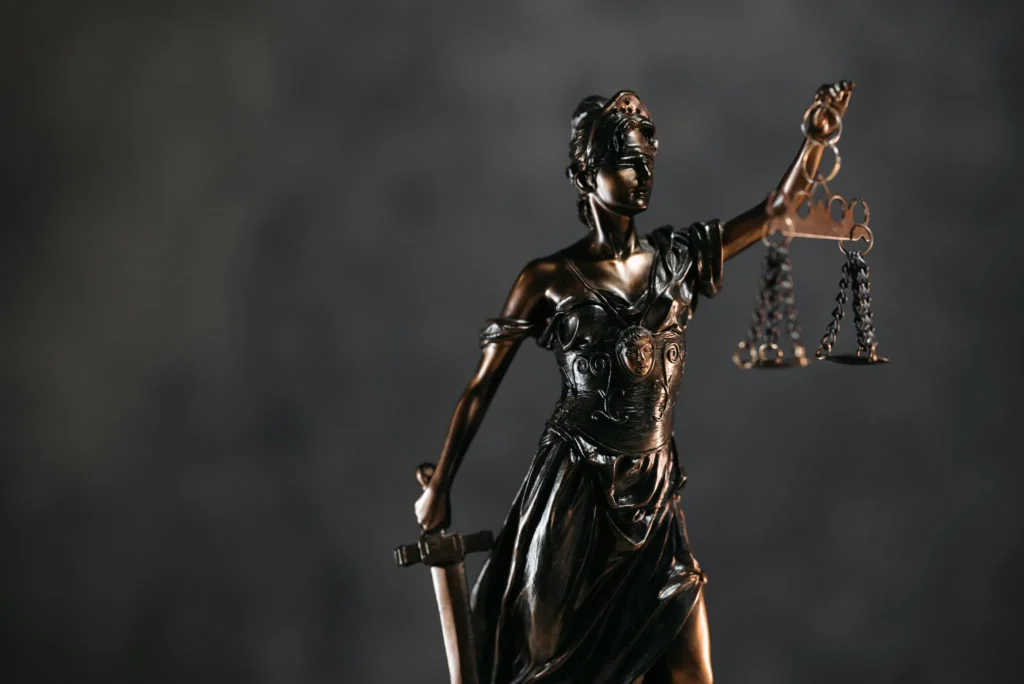 Statue de la justice tenant une balance et une épée, symbolisant l’équité, la loi et l’impartialité.