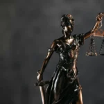 Statue de la justice tenant une balance et une épée, symbolisant l’équité, la loi et l’impartialité.